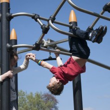 Standing Girl and Hanging Boy playing on Proludic Play Equipment